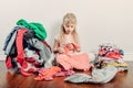 Mommy little helper. Cute Caucasian girl sorting clothes. Adorable funny child arranging organazing clothings. Kid with messy