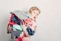 Mommy little helper. Cute Caucasian girl sorting clothes. Adorable funny child arranging organazing clothing. Kid holding messy Royalty Free Stock Photo
