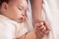 Mommy is always there, even in my dreams. A baby girl sleeping while holding her mothers hand. Royalty Free Stock Photo