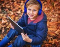 Mommy told me to play outside. High angle portrait of an adorable little boy using a tablet while sitting outdoors Royalty Free Stock Photo