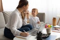 Moms can balance work and family. Young mother multitasking and working from home and spending time with son