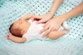 Moms hands gently and carefully hold the newborn baby in his crib