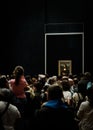 Mona Lisa in the Louvre Museum surrounded by a crowd of people.