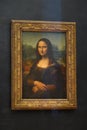 The Mona Lisa original painting on display in the Louvre Museum. The Mona Lisa is a half-length portrait painting by Italian artis