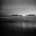 Night ocean long exposure with city lights in the distance Mona Vale New South Wales Australia square format monochrome film analo Royalty Free Stock Photo