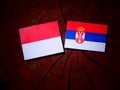 Monaco flag with Serbian flag on a tree stump isolated