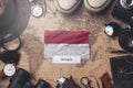 Monaco Flag Between Traveler`s Accessories on Old Vintage Map. Overhead Shot Royalty Free Stock Photo