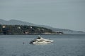 Monaco, lonely mega yacht in sea at sunset, island is nearby, huge motor boat, wealth life of billionaires, mountains on