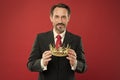 Monarchy attribute. Monarchy family traditions. Man bearded guy in suit hold golden crown symbol of monarchy. Become Royalty Free Stock Photo
