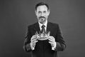 Monarchy attribute. Monarchy family traditions. Man bearded guy in suit hold golden crown symbol of monarchy. Become Royalty Free Stock Photo