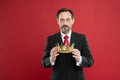 Monarchy family traditions. Man bearded guy in suit hold golden crown symbol of monarchy. Become king ceremony. Award Royalty Free Stock Photo