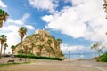 Monastery Sanctuary church Santa Maria dell Isola on top of rock of Tyrrhenian Sea and green palm trees, blue sky with white Royalty Free Stock Photo
