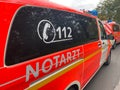 View on red german emergency ambulance with lettering notarzt and telephone number 112