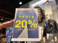 View on isolated card board showing 20 percent discount on jeans in fashion store