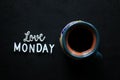 Monday coffee. A cup of morning coffee on black table background with text sign on dark table - love MONDAY.