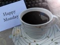 Monday concept with text Happy Monday on white paper and a cup of morning black coffee on the table. Monday with morning coffee. Royalty Free Stock Photo