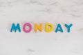 Monday word written with colorful letters on white marble stone background Royalty Free Stock Photo