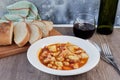 Mondongo a la espanola or cayos a la espanola. Presented on a white plate, on a wooden table Top view. View at 45 degrees.