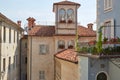 Mondovi, building with little tower and balcony with flowers in a sunny day, blue sky in Italy