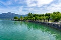 06.05.2021 - Mondsee, Austria: Mondsee with mountains and the beautiful promenade with people and ships