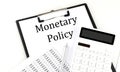MONETARY POLICY text on folder with chart and calculator on white background Royalty Free Stock Photo