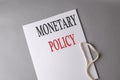 MONETARY POLICY text on white folder on grey background