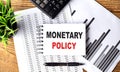 MONETARY POLICY text written on paper clipboard with chart and calculator