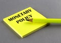 MONETARY POLICY text written on a sticky on grey background