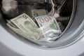 Money in an automatic washing machine are close-ups. Many banknotes are inside Washer. A lot of cash dollars is washed in the drum