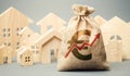 Money bag with arrow up and miniature wooden houses. The concept of rising property prices. High mortgage rates. Expensive rental Royalty Free Stock Photo