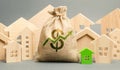 Money bag with arrow up and miniature wooden houses. The concept of rising property prices. High mortgage rates. Expensive rental