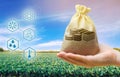 Money bag on the background of agricultural crops in the hand of the farmer. Agricultural startups. Profit from agribusiness. Royalty Free Stock Photo