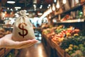 Money bag on the background of a grocery store counter with fresh organic vegetables and fruits. Concept of cost of goods and food