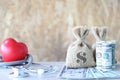 Money bag with banknote and stethoscope with red heart on wooden Royalty Free Stock Photo
