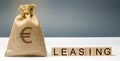 Money bag and blocks with the word Leasing. A lease is a contractual arrangement calling for the lessee to pay the lessor for use Royalty Free Stock Photo