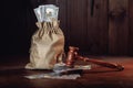 Money bag with dollar banknotes and judge's gavel. Litigation, dispute resolution, conflict of interest settlement Royalty Free Stock Photo