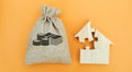 Money bag and a house with puzzles. Real estate investment concept. Business and finance. Mortgage, loan, taxes, debts. Family Royalty Free Stock Photo