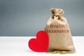 Money bag with the inscription Health Insurance and a red heart. The concept of medical insurance of life, family, health. Royalty Free Stock Photo