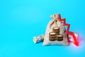 Money bag and red arrow down. Falling economy. Decrease in interest rate deposit rate. Inflation. Low real incomes, economic Royalty Free Stock Photo