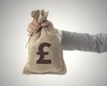 Money bag with Pound sign business man holding up Royalty Free Stock Photo