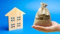 Money bag and wooden house. Real estate investment concept. Business and finance. Mortgage, loan, taxes, debts. Family home budget Royalty Free Stock Photo