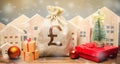 Money bag, wooden houses, Christmas tree and gifts. Christmas Sale of Real Estate. New Year discounts for buying housing. Purchase Royalty Free Stock Photo