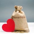 A money bag with the word Donation and a red heart. Accumulation of money for a medical donation. Health care. Saving. Social Royalty Free Stock Photo