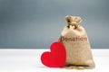 A money bag with the word Donation and a red heart. Accumulation of money for a medical donation. Health care. Saving. Social Royalty Free Stock Photo