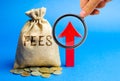 Money bag with the word Fees and up arrow. Duty increase concept. Trade wars. Import and export quotas. High taxation. Free Royalty Free Stock Photo