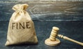 Money bag with the word Fine and the judge`s hammer. Penalty as a punishment for a crime and offense. Financial punishment. Royalty Free Stock Photo