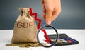 Money bag with the word GDP and down arrow. Decline and decrease of GDP - failure and breakdown of economy and finances leading to Royalty Free Stock Photo