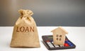 Money bag with the word Loan and a house on the calculator. Loan calculating. Interest rates calculation. Real estate credit. Loan