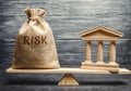 A money bag with the word Risk and a bank building on the scales. The concept of financial and economic risk. Unreliable Royalty Free Stock Photo