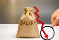 Money bag with the word Salary and arrow to down. lower salary, wage rates. demotion, career decline. lowering the standard of Royalty Free Stock Photo